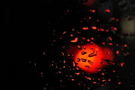 Water drops on window in rainy night  Lighted with red light の写真素材