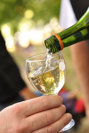 Man pours white wine into a glassの写真素材