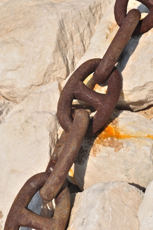 Detail view of old rusty ship chain on stoneの写真素材