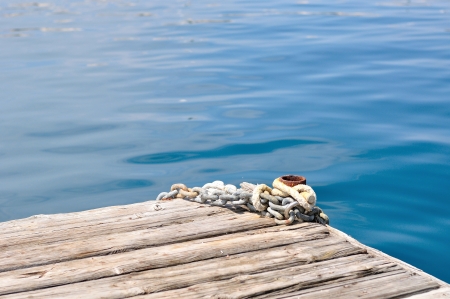Metal ship chains and bollard on wooden pier  Podgora, Croatia