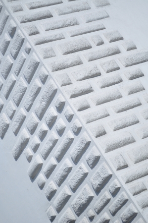 Close-up shot of the corner of white wall decorated with bricksの写真素材