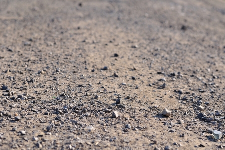 Terrain road with small rocks on the ground viewed from near the groundの写真素材