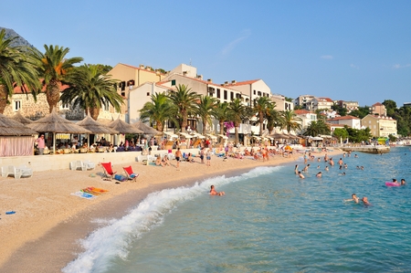 Amazing beach of Podgora with people and hotel Podgorka in background  Podgora is a popular holiday resort in Croatia のeditorial素材