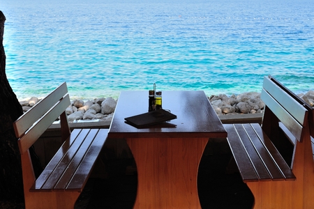 Table with bottles of olive oil and vinegar at tropical beach restaurant, Croatiaの写真素材