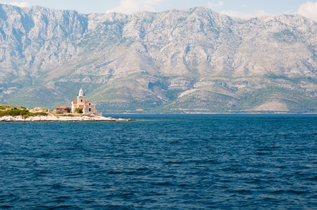 Lighthouse on the south end of island Hvar in the Adriatic sea with mountain Biokovo in background. Sucuraj, Croatiaの写真素材