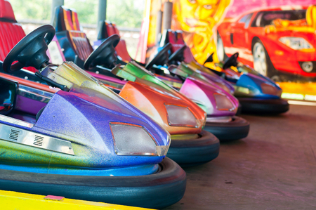 Colorful electric bumper car in autodrom in the fairground attractions at amusement park. Selective focus on the cars