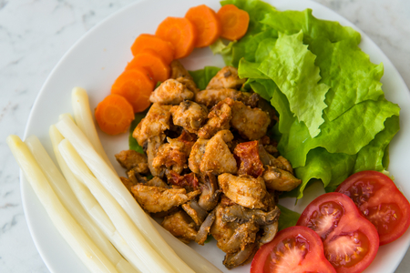 Fried chicken meat served on plate with white asparagus, carrot, tomato and lettuce. Top viewの写真素材