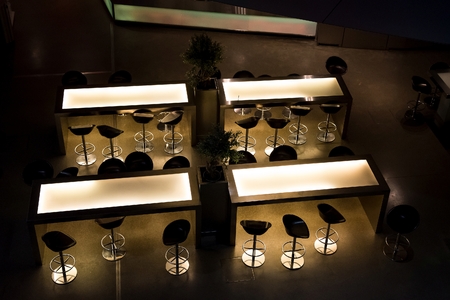 Bar chairs and tables in empty dark barの写真素材