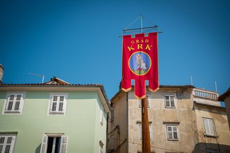 Coat of Arms in the Center Square of town Krk. Buildings in the background. Krk town is a famous touristic destination on Krk island, Croatiaの写真素材