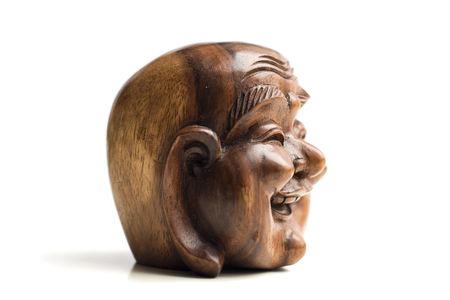 Wooden happy Buddha head statue. Souvenir from Indonesia, Southeast Asia. White background.の写真素材