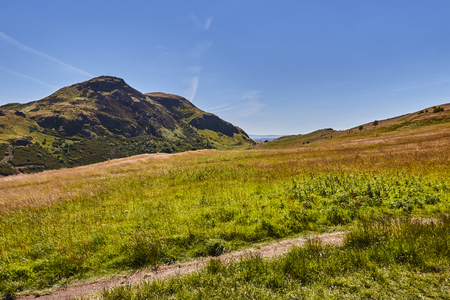 Summer view of Arthur's Seat in Holyrood Park with beautiful green grass and blue sky in Edinburgh, Scotland, United Kingdom.の写真素材