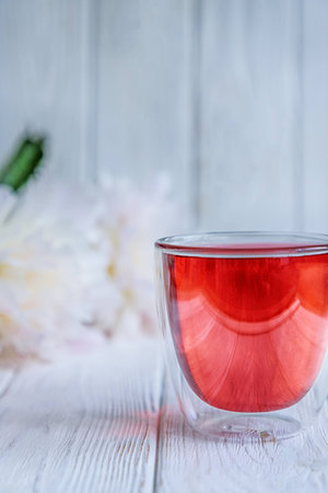 Fruit tea and summer flowers white peonies on white wooden background. Free spaceの写真素材