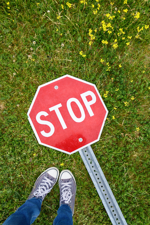 Feet selfie with stop sign on the green grass backgroundの写真素材