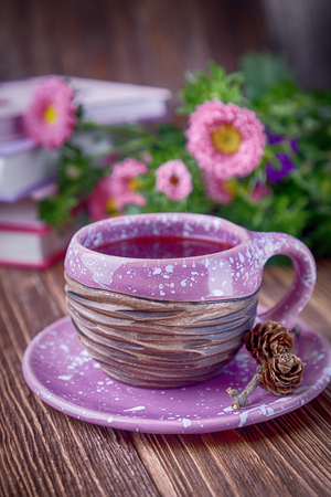 Autumn composition. Fruit tea, books and flowers asters on a wooden backgroundの写真素材