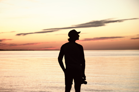 Silhouette of man with the camera and sunset. Photographer and sunsetの写真素材