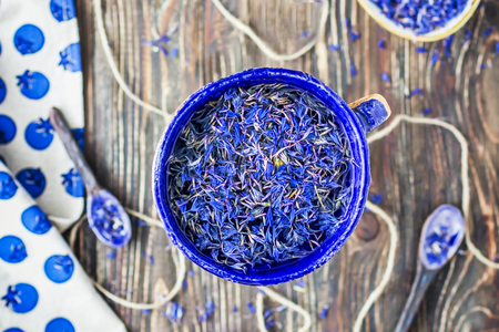 Cup of dried cornflowers on the wooden background. Top viewの写真素材