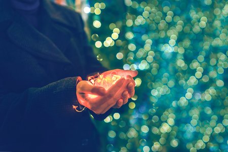 Garlands in the palms. Christmas lights in the hands. Soft focusの写真素材