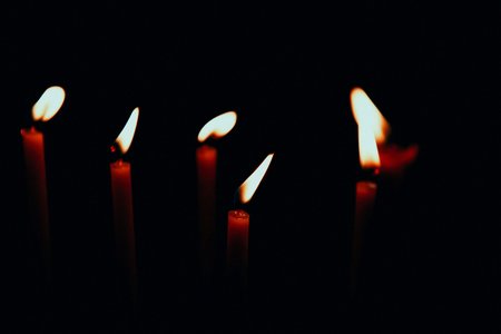 Thin red candles on a black background. Low keyの写真素材