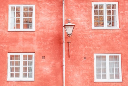 Coral color wall, street lantern and four white windows. Copy spaceの写真素材