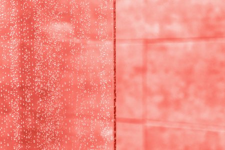 Coral color background. Waterdrops on a glass. Copy spaceの写真素材