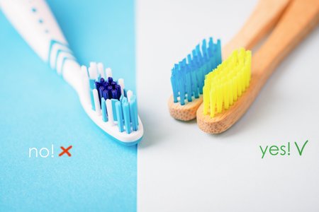 Plastic and bamboo toothbrushes on blue and white background. Alternative concept. Toothbrush...