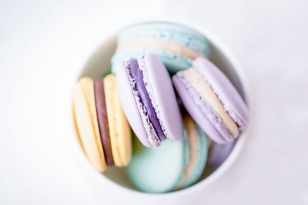 Sweet colourful pastel french macaroons or macaron on white background. Top view, copy spaceの写真素材