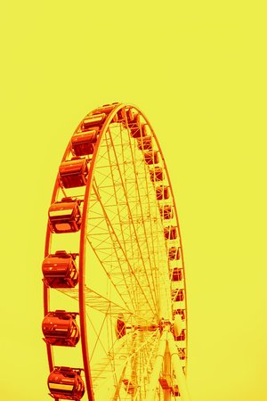 Orange ferris wheel on a bright yellow backgroundの写真素材