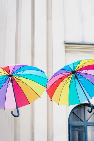 Colored rainbow umbrellas on the light old wall backgroundの写真素材