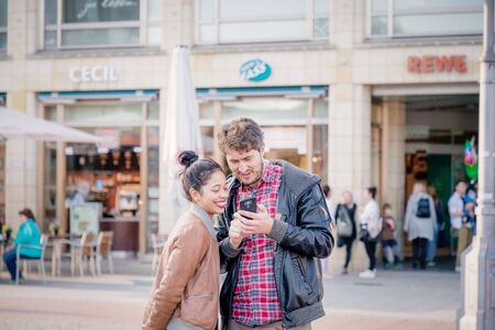 Weimar, Germany. March 30, 2019. Beautiful young happy couple looking at smartphone display in the city centerのeditorial素材