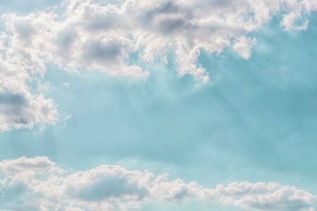 Delicate light rays through clouds on a pastel aqua color sky background