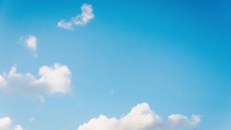 Beautiful small white fluffy clouds on a light blue sky background. Copy space, 16:9 panoramic...