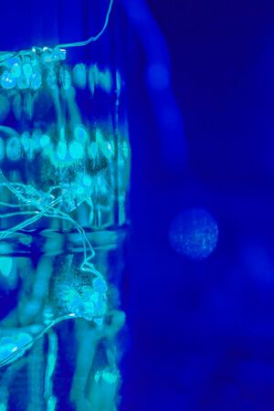 Magic blue and aqua menthe mint green color. Green garland in the bottle, abstract backgroundの写真素材