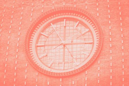 Big clock on a dark wall. Details. Church of the most sacred heart of our Lord. Coral color toned. Prague, Czech Republicの写真素材