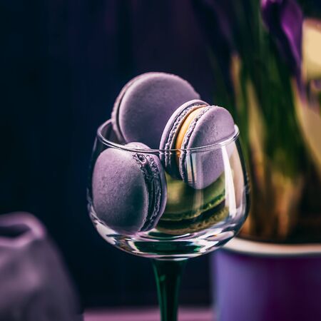 Exquisite french violet purple lavender macaroons or macarons in a glass on dark backgroundの写真素材
