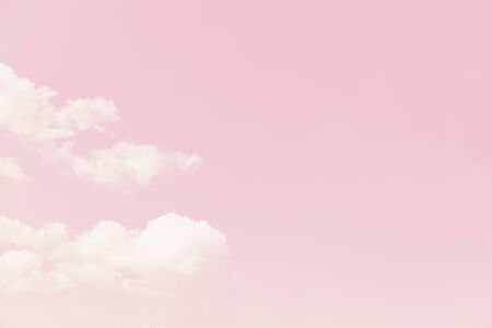 Beautiful white fluffy clouds on a pale pink sky backgroundの写真素材