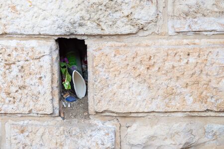 Niche or hole with garbage in the old wall in Jerusalem, Israel. Details. Copy space