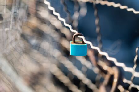 Old rusty turquoise padlock on the bridge. Sunlight, blurred background. Copy spaceの写真素材