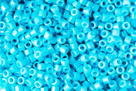 Turquoise small identical shiny beads, textured background