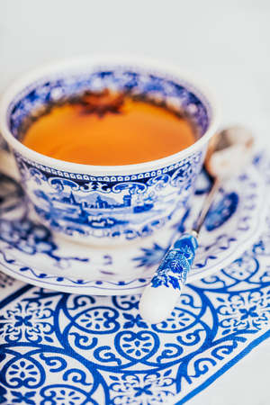 A cup of orange lemon tea with anise star, white and blue dishes. Copy spaceの写真素材