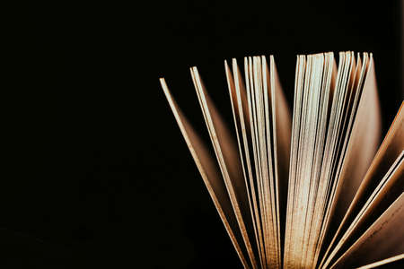 Opened old vintage book with gold pages on a black background. Copy spaceの写真素材