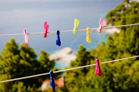 Colored plastic clothespins on clothesline on the sea background. Brela, Croatiaの写真素材