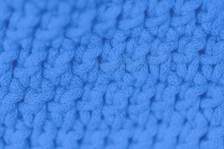 Blue color background. Full frame shot of knitted fabric, blurred