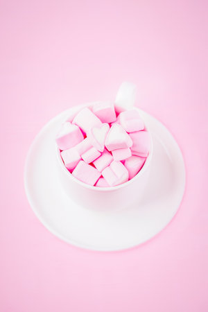 Valentine's day background with pink marshmallow hearts in a cup, copy spaceの写真素材