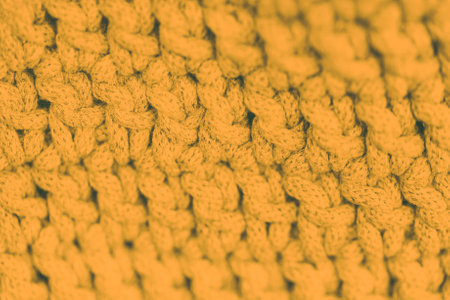 Yellow mustard color background. Full frame shot of soft knitted fabric, blurredの写真素材