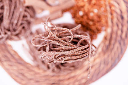 Uncooked gluten free buckwheat pasta on ceramic plate