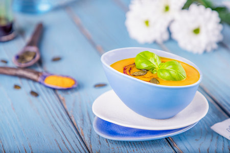 Pumpkin cream soup on a blue backgroundの写真素材