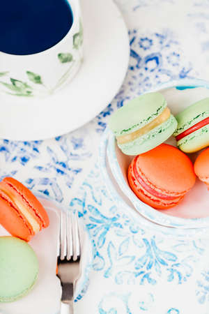 Blue butterfly tea and green and orange macaroons or macarons, copy space