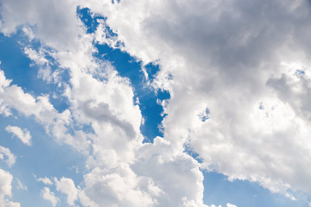 Blue sky and white fluffy clouds backgroundの写真素材