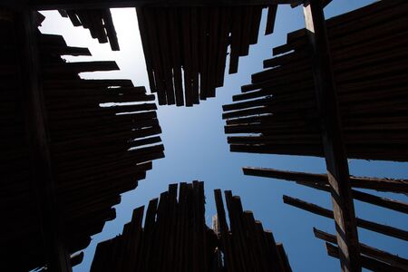 Wooden roof dark old yurt with sky. Bottom up through the roof to the sky. The roof of the wooden...