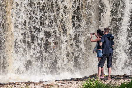 Tourists take pictures of the waterfall very close. Much water. Powerful flow. The water is blurry.のeditorial素材